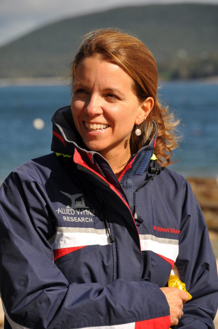 mindy from waist up, in front of ocean