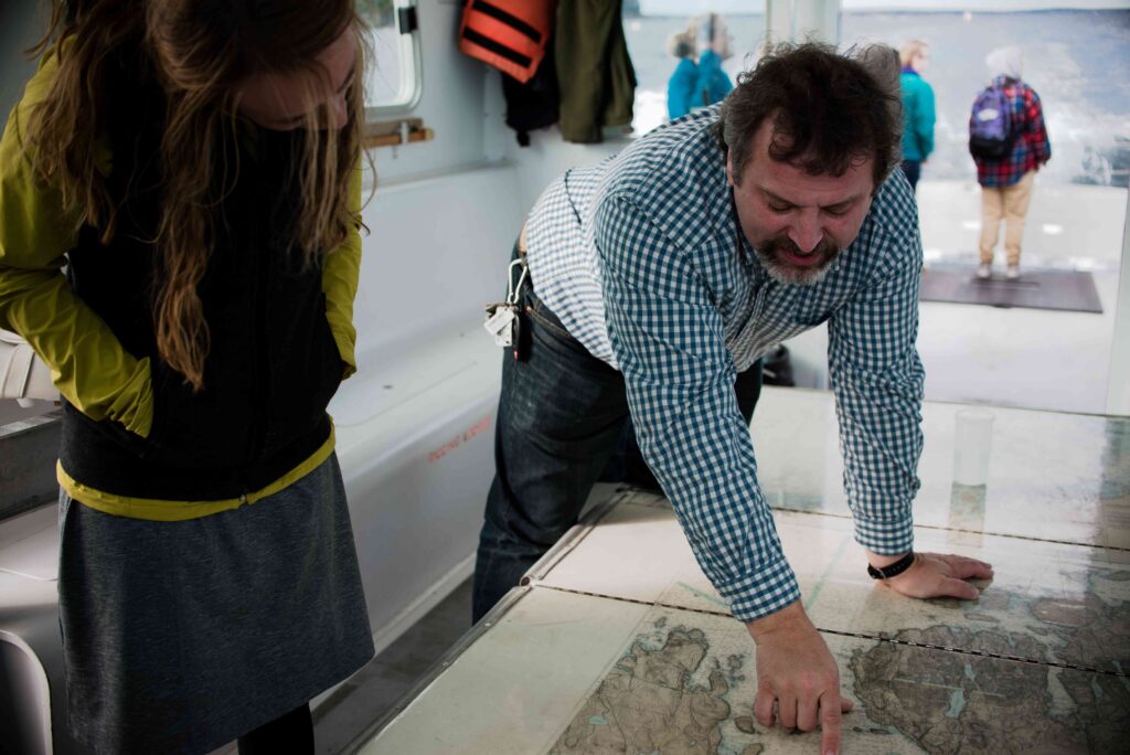 Man pointing at map, woman observing.