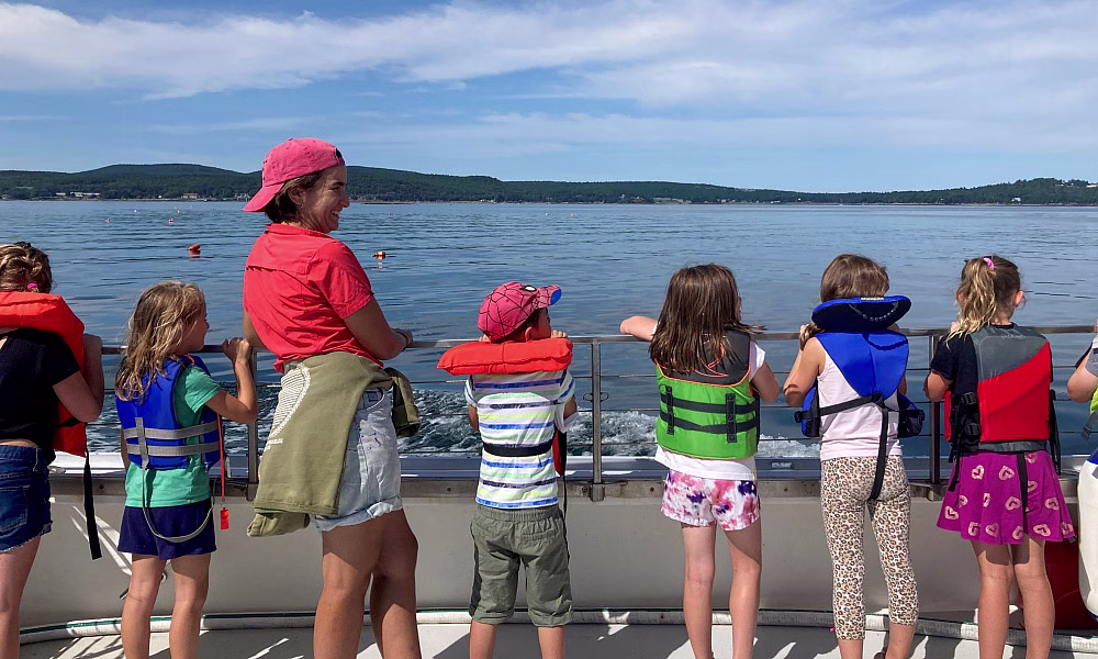 Children observing water from boat.