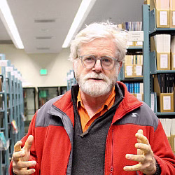Person gesturing in library setting.