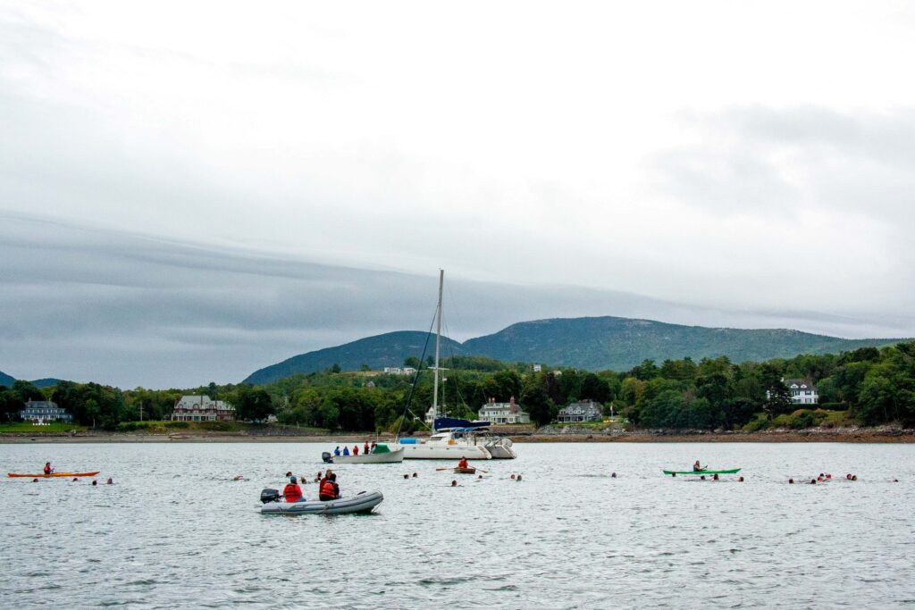 Boats and swimmers in calm water.