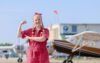 Person posing near small airplanes.